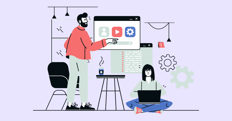 A man in a red jacket points at a computer screen displaying social media icons while a woman sits with a laptop, engaged in work. The background features modern office elements, including plants and decorative lights, creating a collaborative workspace atmosphere.